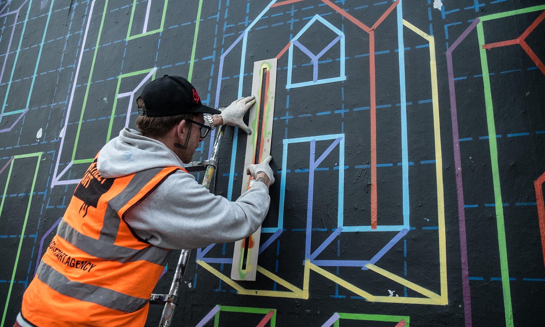 Artist creating mural on Great Eastern Art Wall in Shoreditch