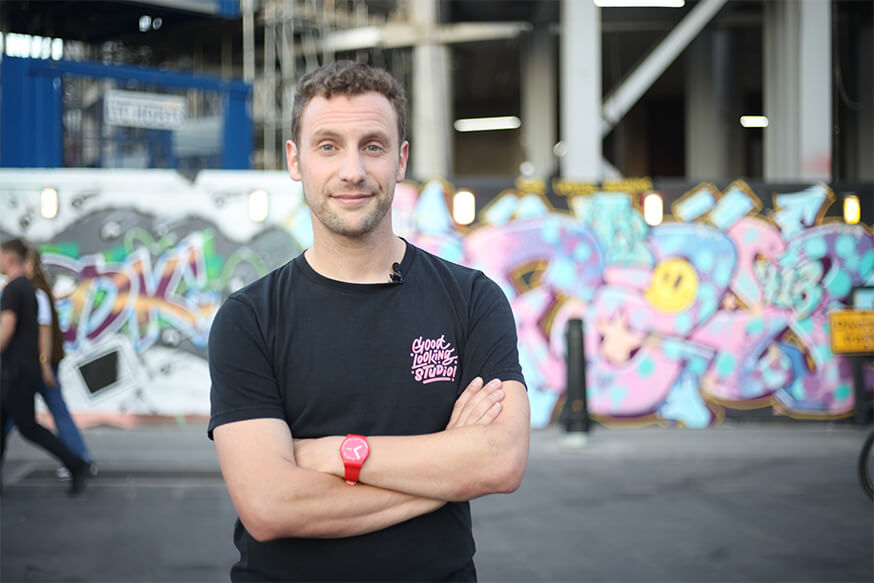 Dr Lee Bofkin standing in front of an art mural in East London