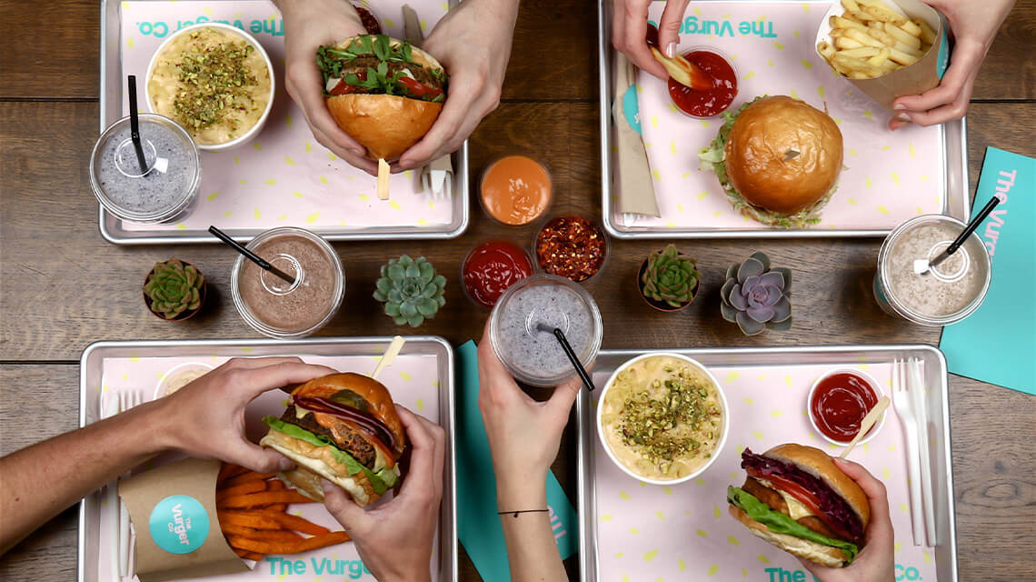 Four people eating vegan burgers at Vurger, Shoreditch