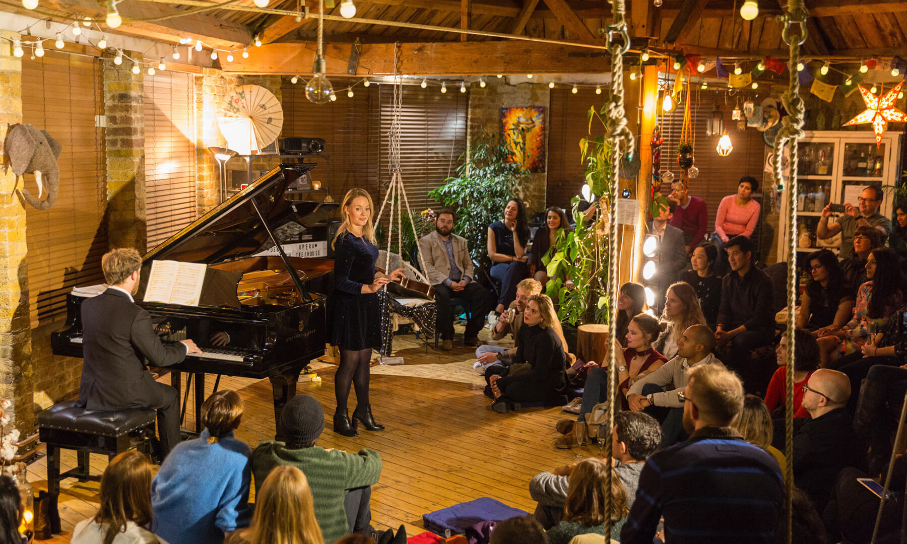 A lady singing to an audience at Debut Treehouse