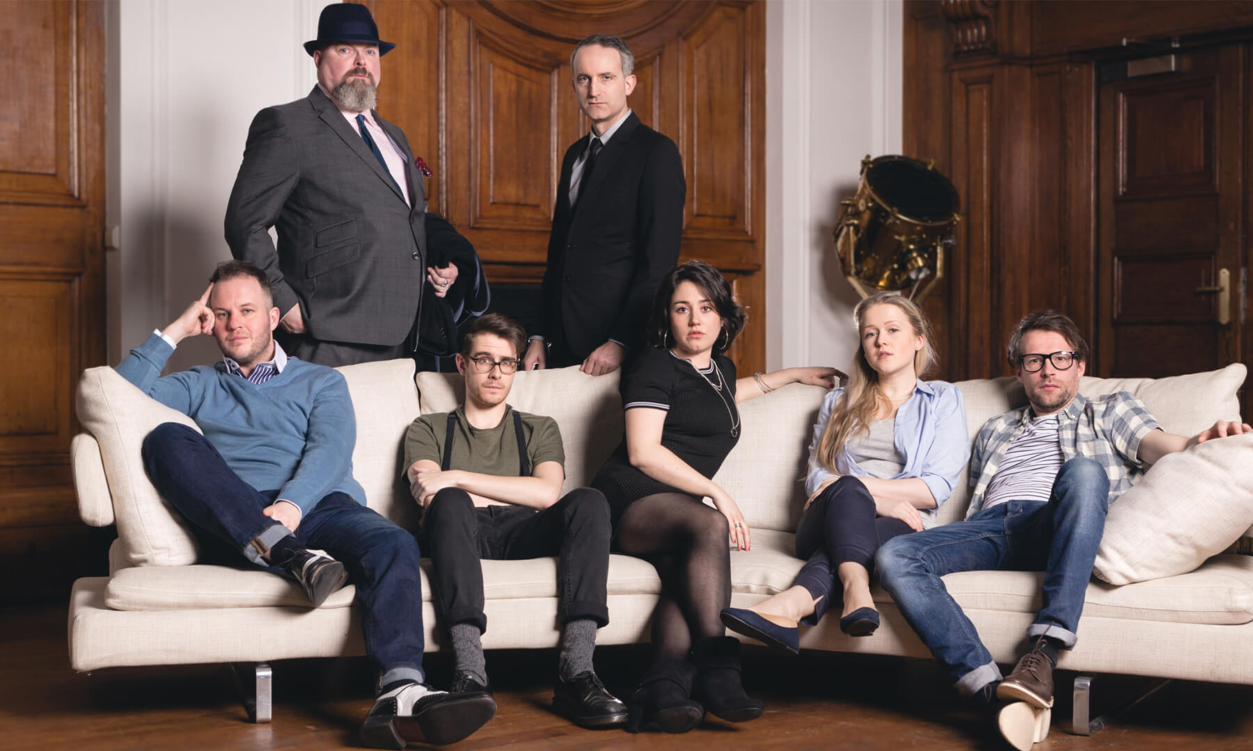 The cast of The Grift on a sofa