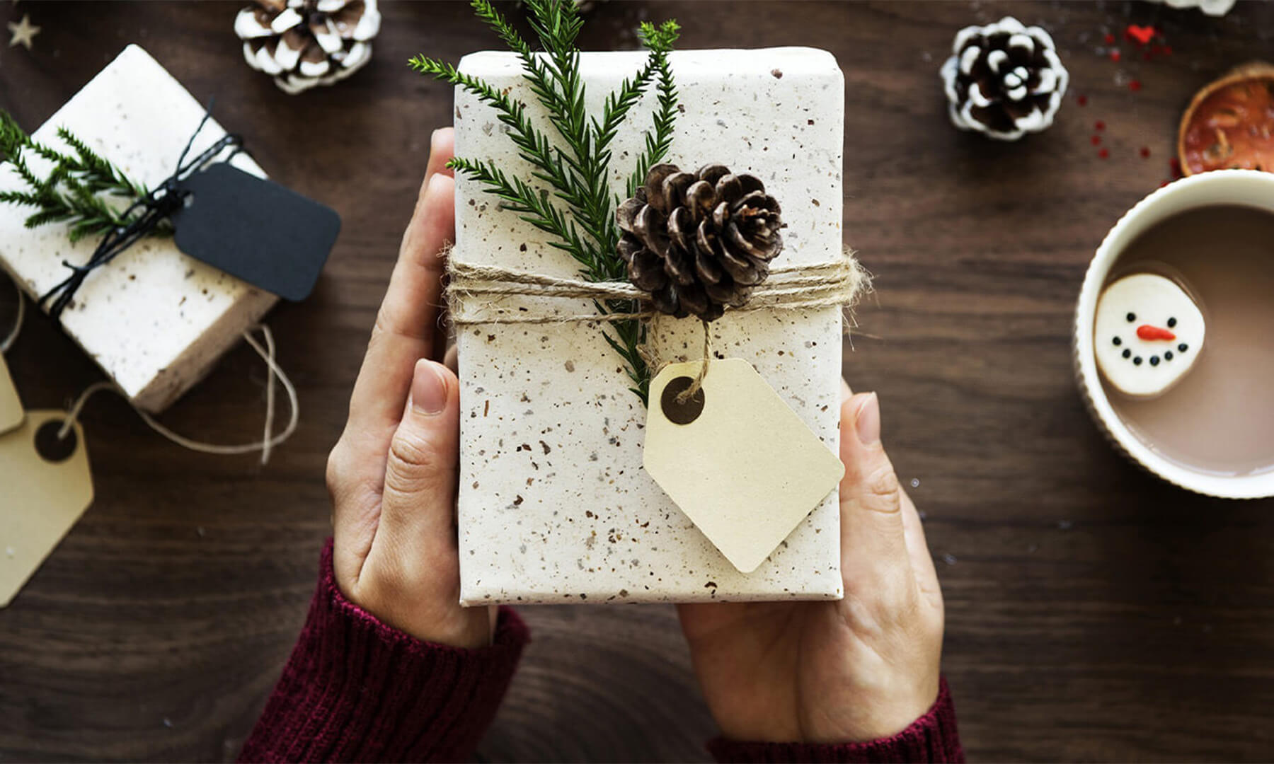 A giftwrapped present with a pinecone for decoration